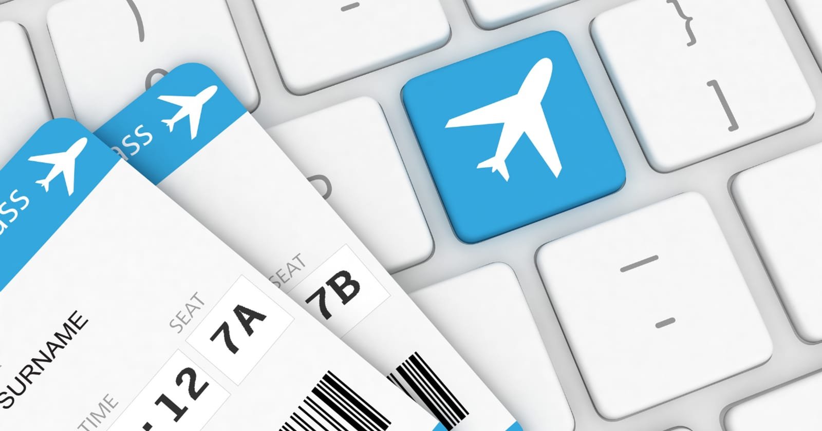 Two boarding passes lying on a keyboard beside a booking key marked with an aircraft